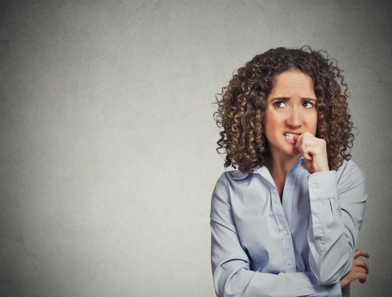 Anxious woman biting her nails because of OCD