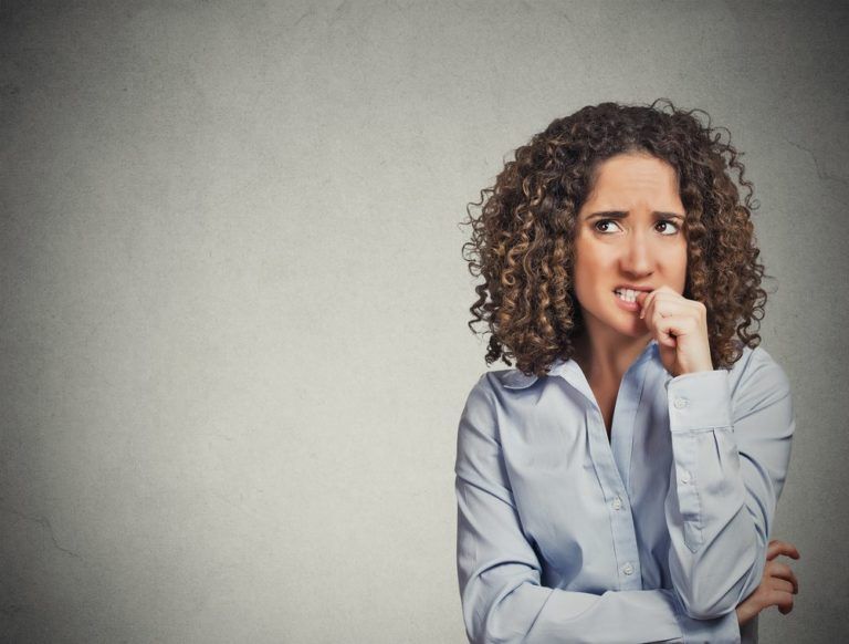 Anxious woman biting her nails because of OCD